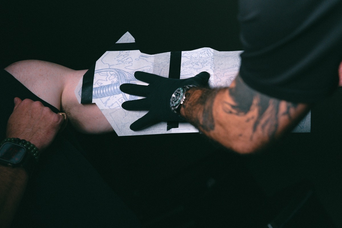 The stencil pressed against the forearm, finding its position on the body