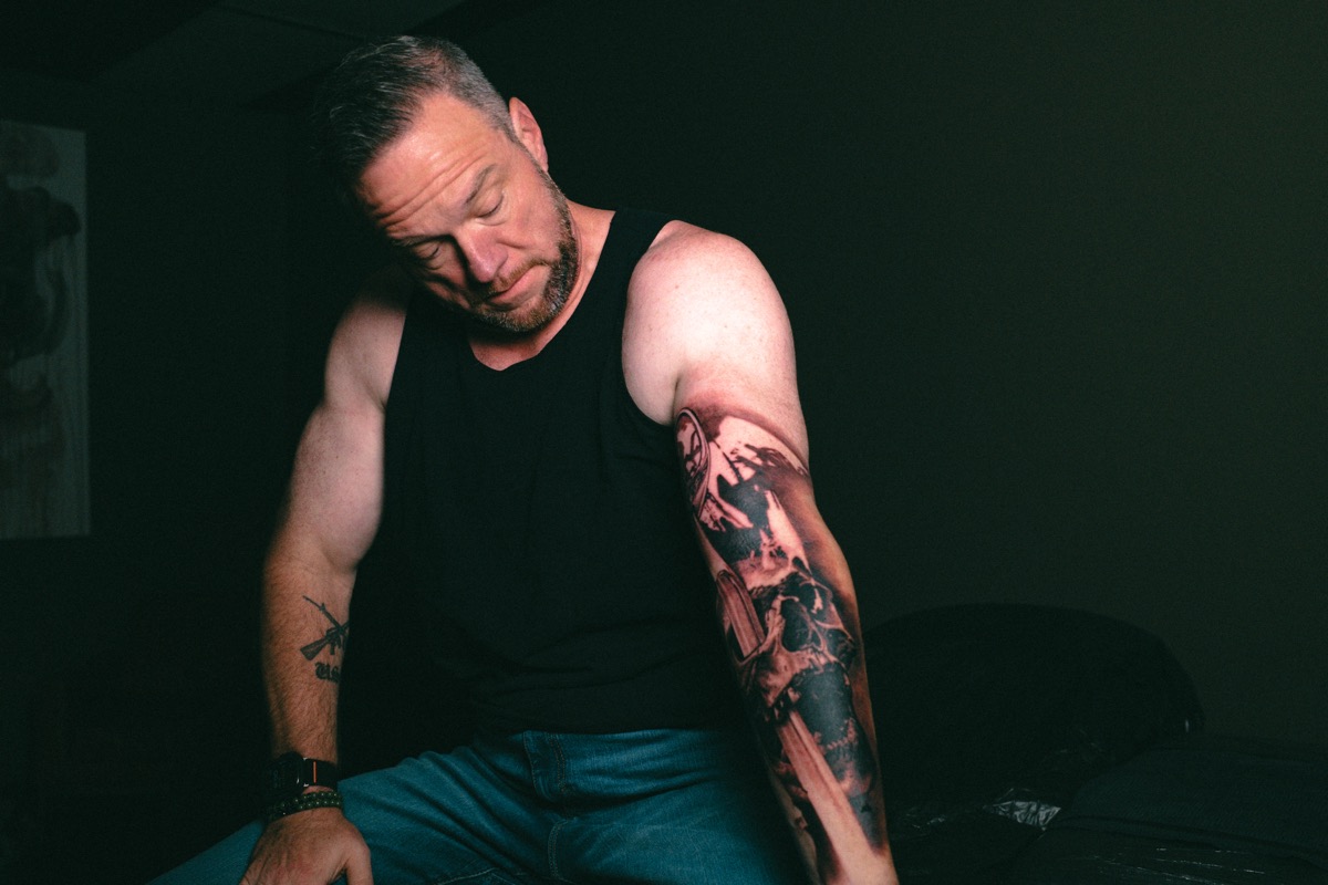 The client sitting quietly, looking down at the finished piece on his arm